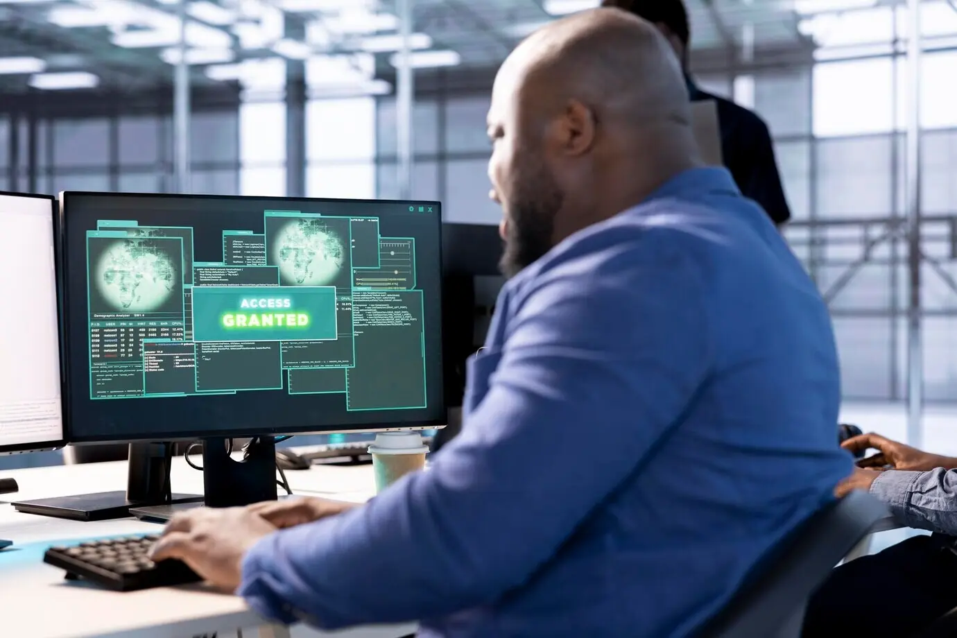 Мужчина, перенастраивающий серверный хаб, получает на мониторе уведомление «Доступ предоставлен».