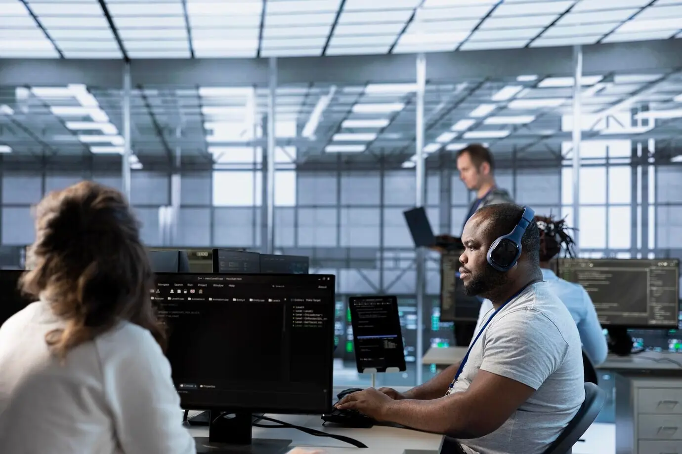 Сотрудник в серверной ферме слушает музыку, настраивая и тестируя оборудование.